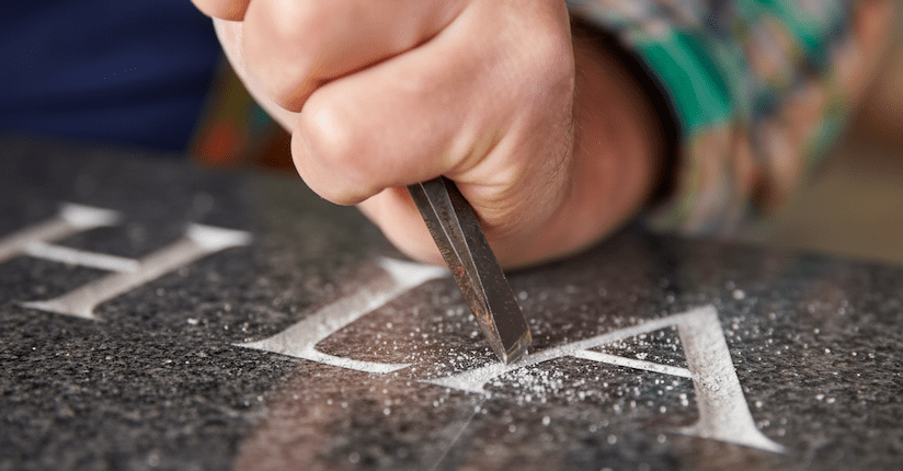 Paminklų gamyba Vilniuje – patyręs meistras dirba su akmeniu